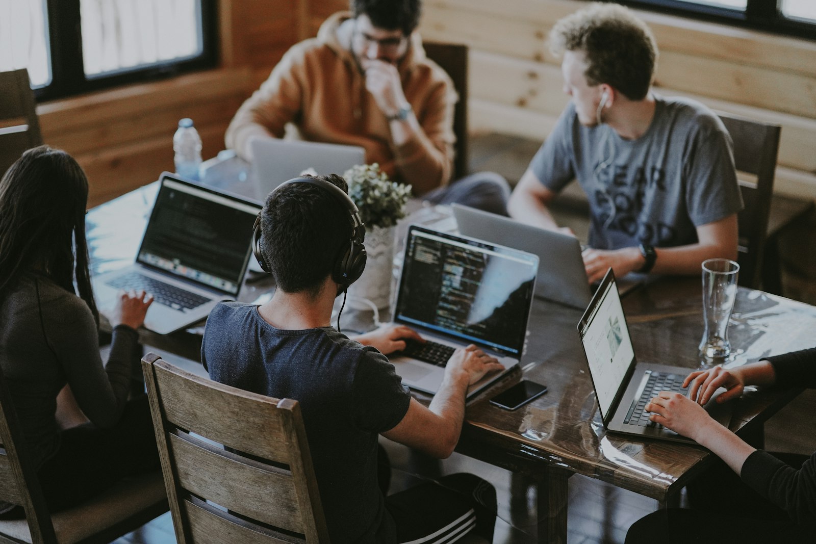 A team collaborating around laptops in a coding session